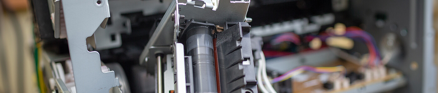 A specialist repairs an industrial printer in a facility