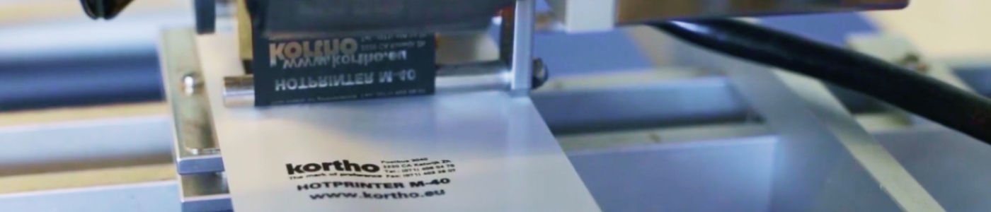 Tête d’imprimante à transfert thermique ayant imprimé par transfert de chaleur une description sur une surface blanche.