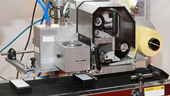Imprimante applicatrice d'étiquettes intégrée à une ligne de production rapide