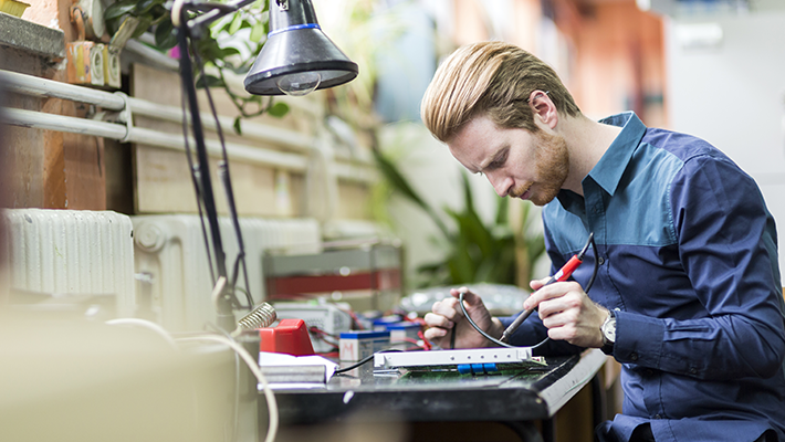 Un technicien effectue la réparation minutieuse d'un système de marquage en atelier.